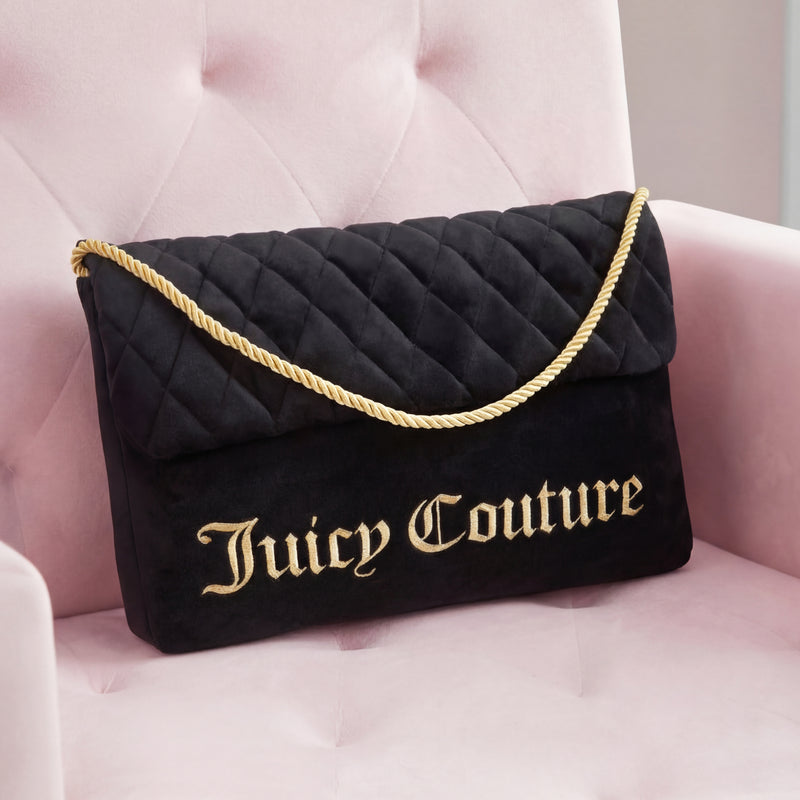 A Purse Decorative Pillow styled as a black quilted bag with gold lettering and a thick gold rope strap sits on a pale pink velvet chair, complemented by an accent pillow for a trendy, chic look.