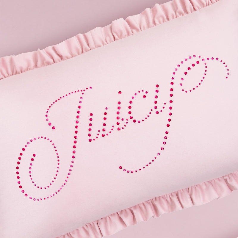 The Ruffle Decorative Pillow is light pink with ruffled edges and features "Juicy" in pink rhinestone cursive across the front.