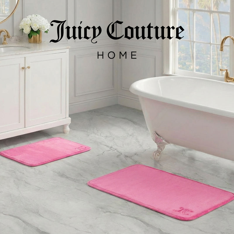 A luxurious bathroom with a white bathtub, marble floors, gold fixtures, and two pink Quilted Memory Foam Bath Mats. The Juicy Couture Home logo is displayed at the top of the image.