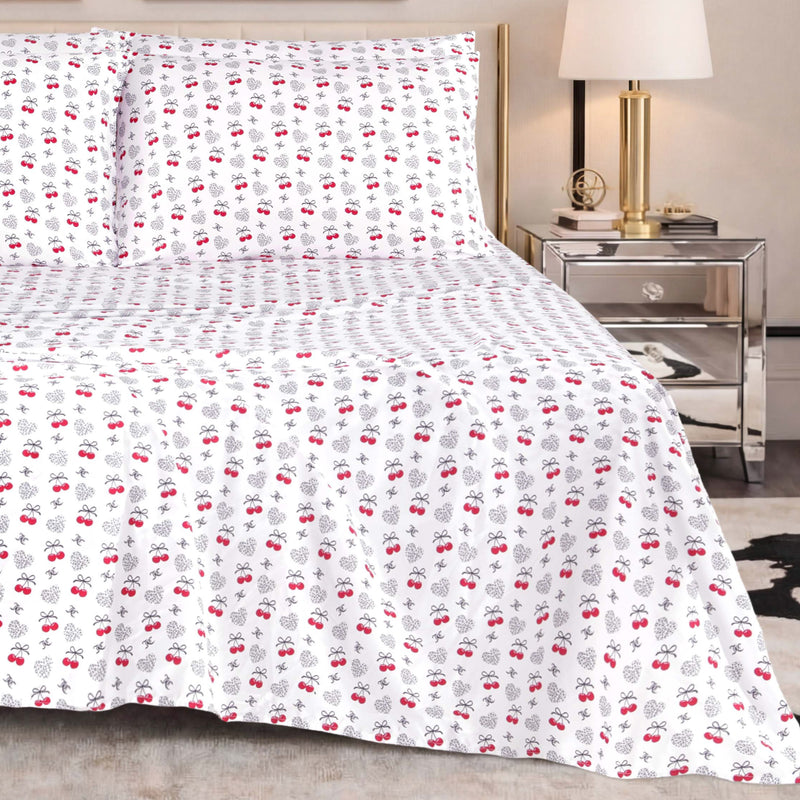 The Microfiber Sheet Set With Extra Pillowcases, featuring a subtle red and black cherry pattern, is paired with a mirrored nightstand topped with a lamp and decorative accents to create a modern bedroom setting enhanced by luxury bedding for superior comfort and style.