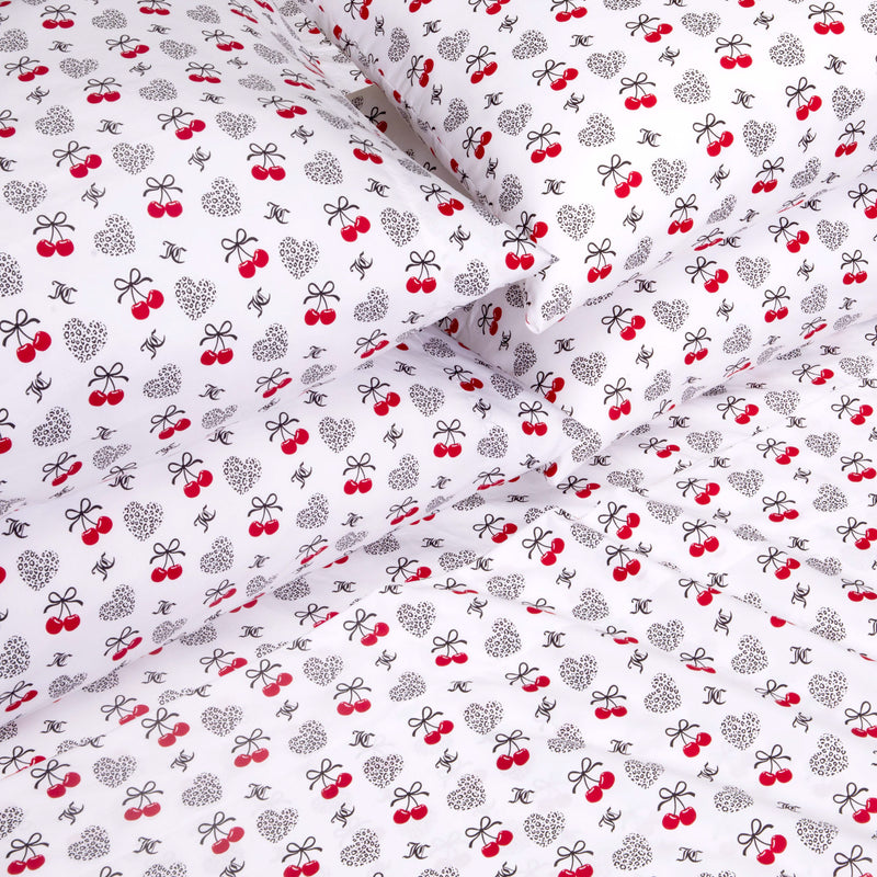 Indulge in luxury bedding with the Microfiber Sheet Set With Extra Pillowcases, showcasing white fabric embellished with black bows, polka-dotted hearts, red cherries, and dainty logo-inspired motifs for a playful and whimsical look. Crafted from premium microfiber, this stylish sheet set delivers both soft comfort and charming appeal to elevate your bedroom retreat.