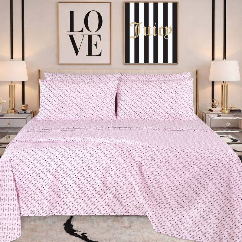 A neatly made bed with pink patterned bedding, featuring a Microfiber Sheet Set With Extra Pillowcases for added style, is flanked by two lamps on mirrored nightstands. Above the bed are two wall art pieces: one says LOVE and the other says Juicy on black and white stripes.
