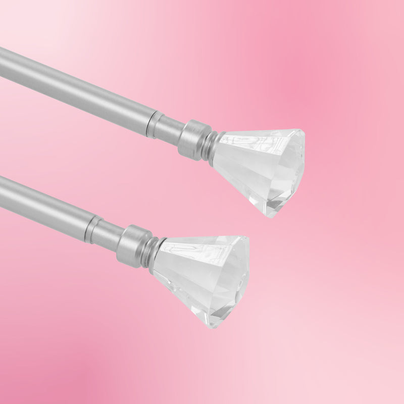 Two Malibu 2-Piece Adjustable Curtain Rod Sets in silver, each featuring clear faceted crystal finials on both ends and a telescoping design, displayed against a soft pink background.