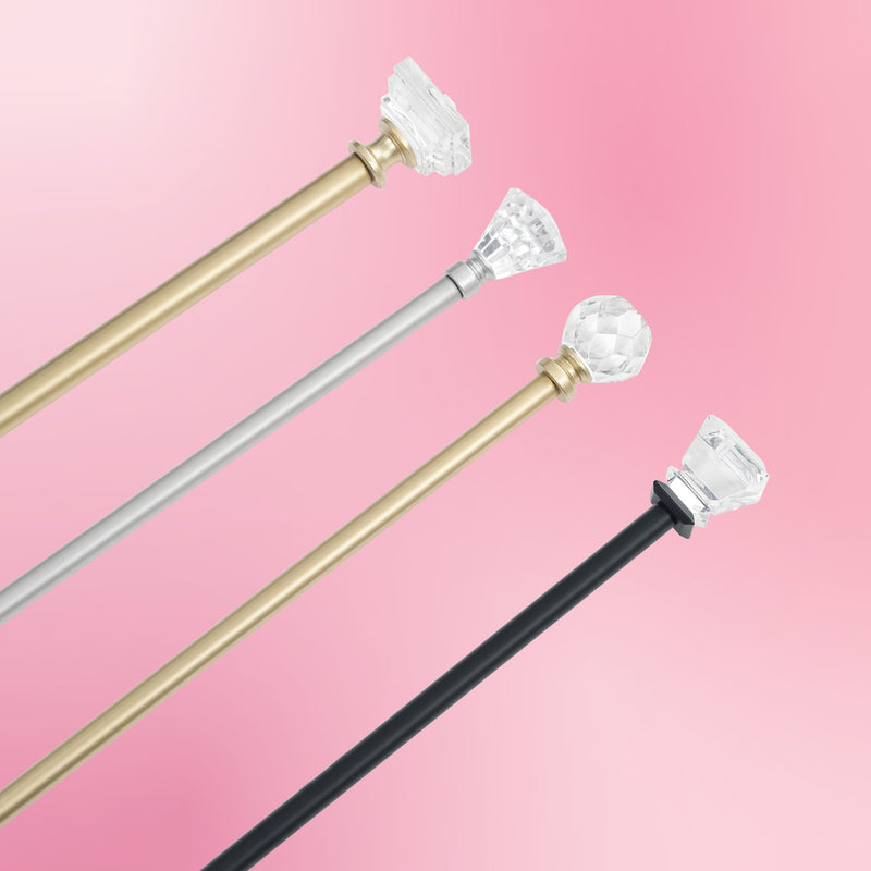 Three Rodeo Adjustable Curtain Rods—one gold with a faceted knob, one silver with a faceted cone-shaped end, and one black with a faceted round end—are displayed diagonally on a pink gradient background, adding signature Juicy Couture flair to your window styling.