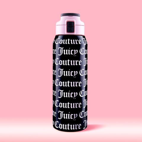 The Glam Getaway Hydration Stainless Steel Tumbler in black features bold white Juicy Couture logos across its surface, a pink and black lid, and is displayed against a solid pink background.