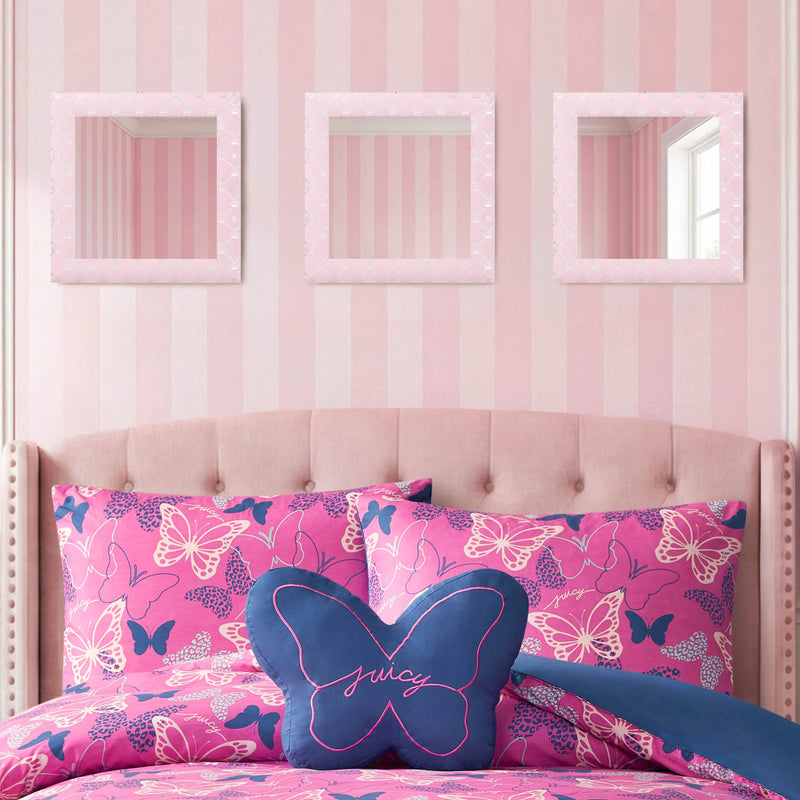 A pink bedroom features a tufted headboard, butterfly-patterned pillows, a blue butterfly pillow, and three square mirrors from the Velour Lattice Crown Foil Print 3-Piece Decorative Mirror Set adorning the pink-striped wall.
