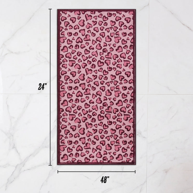 Ultra-soft, rectangular Finley Washable Rug, 2′ x 4′, featuring a pink and dark red heart leopard print, marked with dimension lines showing 24 inches by 48 inches.