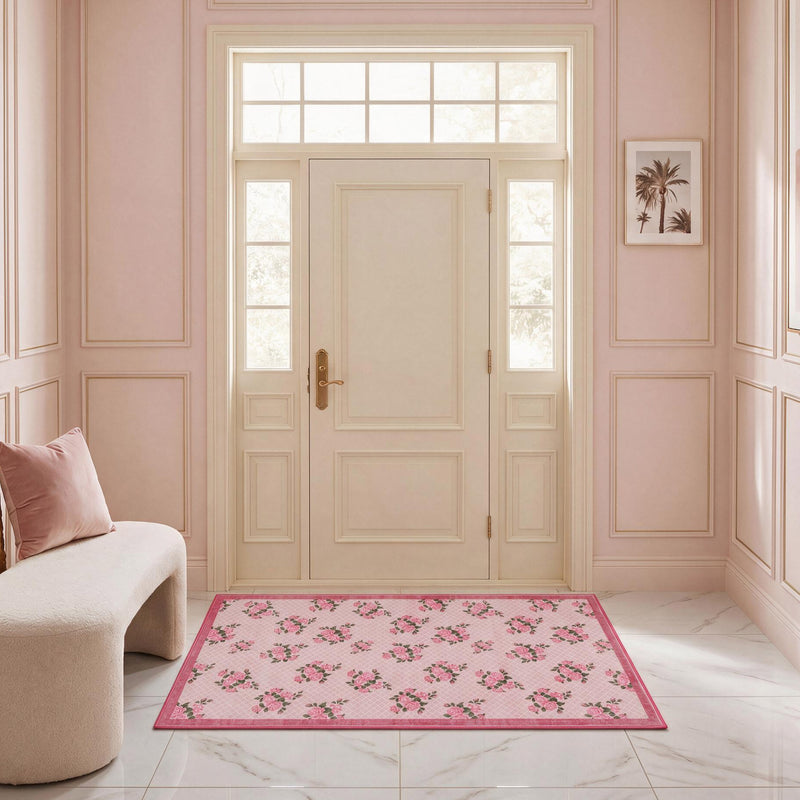 Rectangular ultra-soft Finley Washable Rug, 2′ x 4′, with a pink floral pattern on a trellis background, positioned on a white marble floor in an entryway.