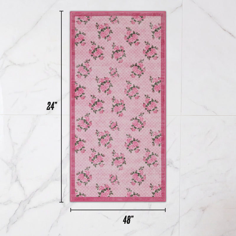 Finley Washable Rug, 2′ x 4′, a rectangular pink Juicy Couture rug with a floral and grid pattern.
