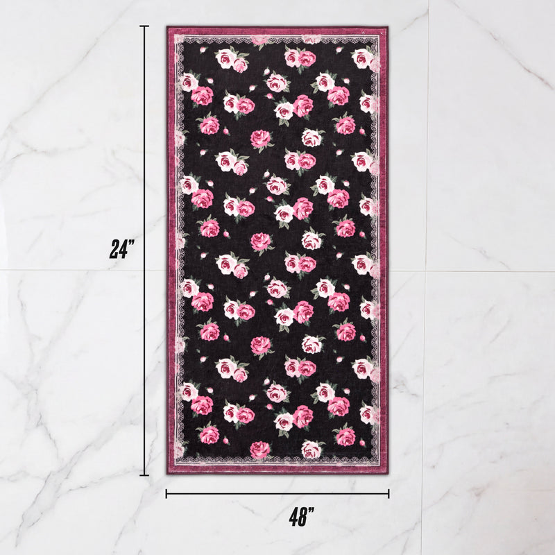 Finley Washable Rug, 2′ x 4′, an ultra-soft rectangular area rug with a black background and a pink rose pattern.