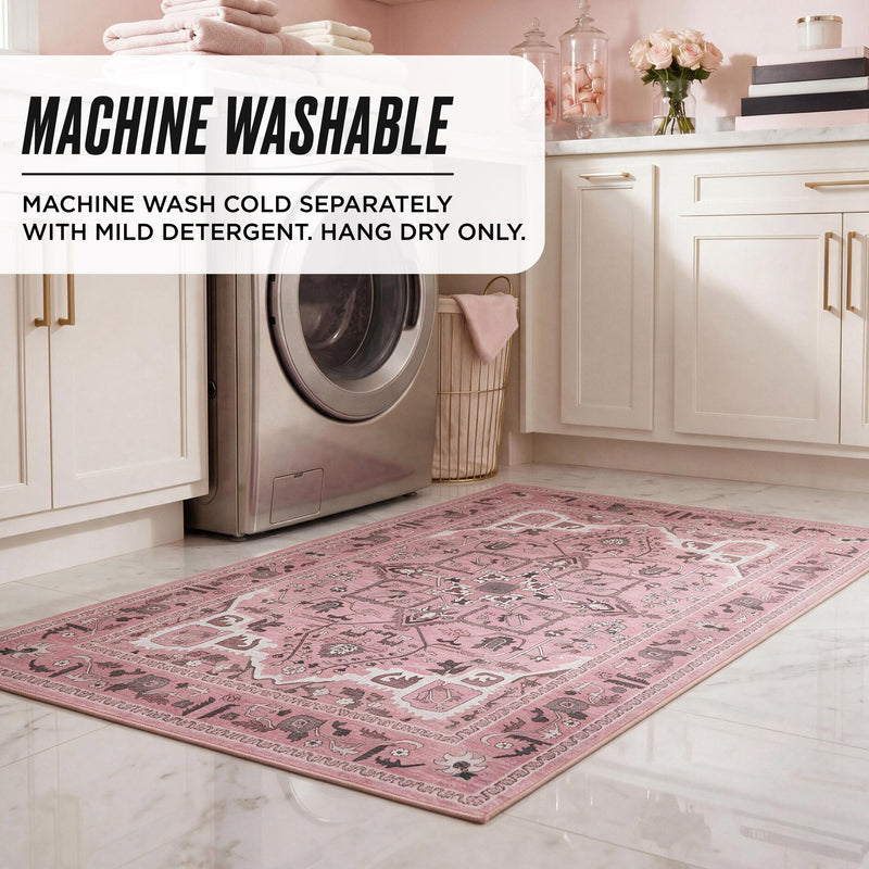 Finley Washable Rug, 2′ x 4′, an ultra-soft, rectangular pink and white patterned machine-washable rug on a marble laundry room floor, with text reading: MACHINE WASHABLE. MACHINE WASH COLD SEPARATELY WITH MILD DETERGENT. HANG DRY ONLY.