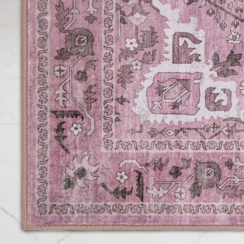 Close-up of a rectangular, ultra-soft Finley Washable Rug, 2′ x 6′, featuring a pink and grey traditional floral pattern and a geometric border.