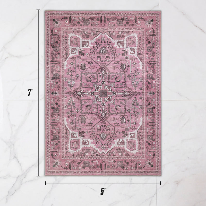 Finley Washable Rug, 5′ x 7′, an ultra-soft rectangular area rug with a vintage-style floral and geometric pattern in pink, white, and charcoal, displayed on a white marble background.