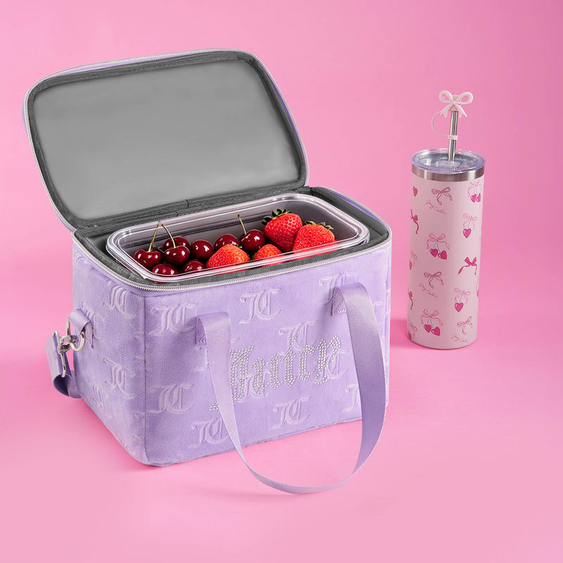 A stylish purple lunch bag filled with fruit sits next to a pink tumbler adorned with a straw and bow, all set against a pink background. This chic scene could easily feature the Chill Couture Cooler Bag as your go-to choice for keeping snacks fresh and fashionable.