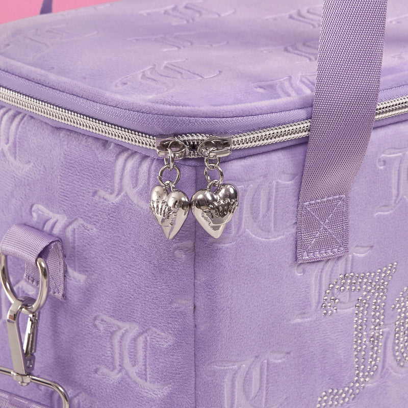 A close-up of the lavender Chill Couture Cooler Bag by Juicy Couture highlights its silver heart-shaped zipper pulls, embossed patterns, and rhinestone initials, showcasing this stylish lunch tote’s elegant details.