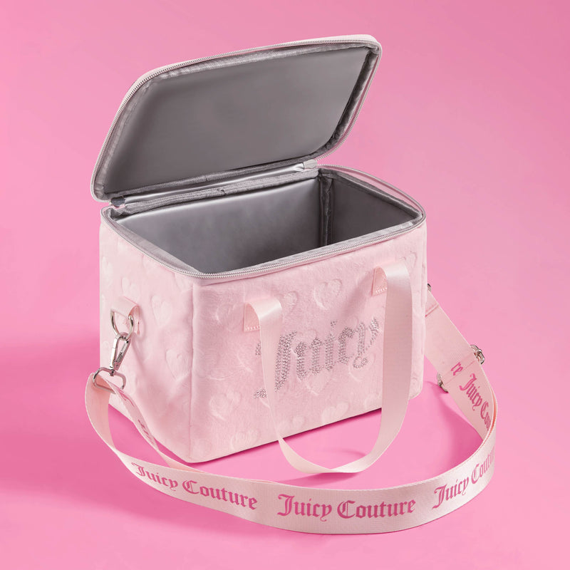 A pink Chill Couture Cooler Bag by Juicy Couture with an open lid, heart patterns, and an adjustable logo strap, set against a pink background. This stylish lunch tote doubles as an insulated cooler bag that keeps your meals fresh while displaying iconic glamour.