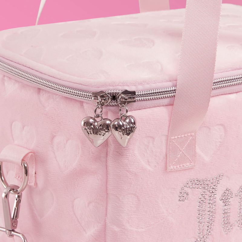 A close-up of the Chill Couture Cooler Bag, showcasing its stylish pink heart-patterned design, silver heart-shaped zipper pulls, pink straps, and sparkling rhinestone decorations against a pink background.