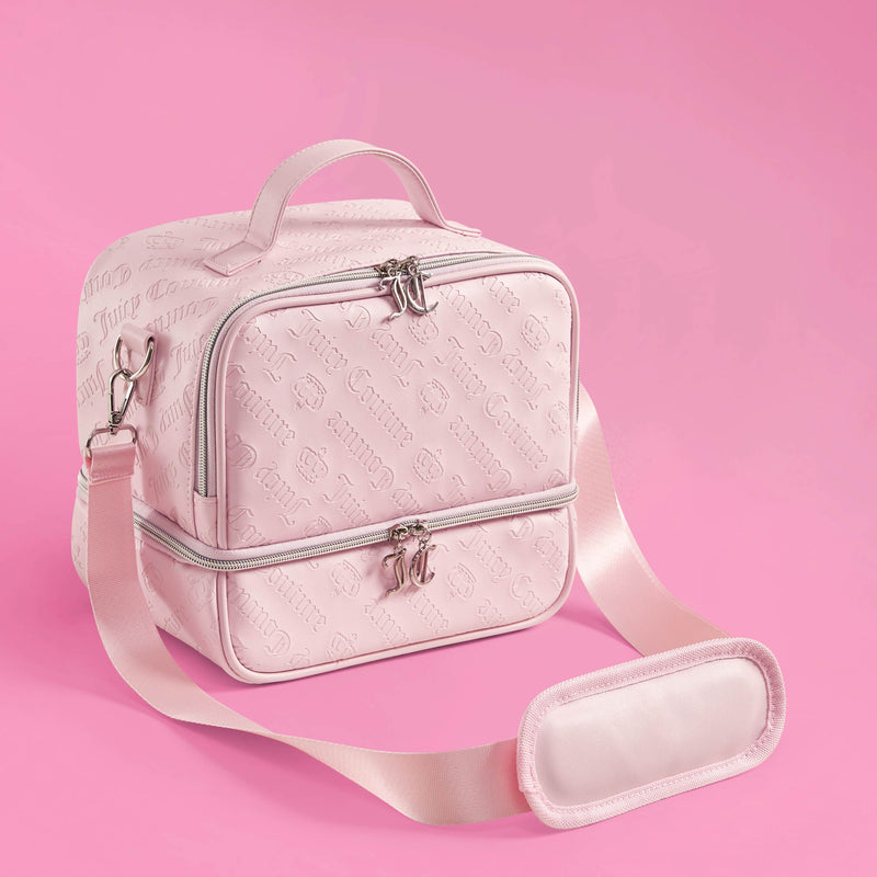 A light pink Double Zip Chill Cooler Bag by Juicy Couture features embossed logos, a top handle, double zip closures, and an adjustable shoulder strap, set against a solid pink background. This chic insulated tote keeps your meals fresh in style.