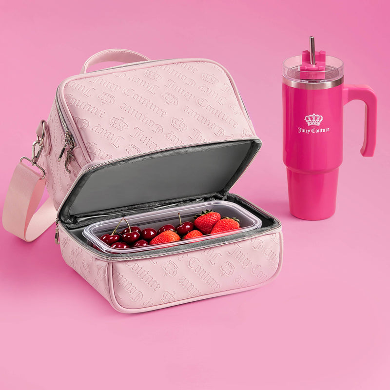 A light pink Double Zip Chill Cooler Bag by Juicy Couture, featuring a gray interior, holds a clear container of cherries and strawberries. Beside it sits a tall, bright pink Juicy Couture tumbler complete with a handle and straw, all arranged on a pink background. This stylish Double Zip Chill Cooler Bag keeps your snacks fresh and cool while adding a touch of luxury to your daily routine.