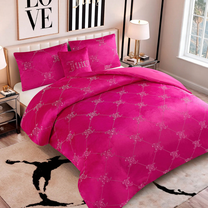 A neatly made bed is adorned with the Velvet Rhinestone Logo Link Bling Comforter Set, featuring plush pink velour and eye-catching rhinestone logo accents for added glamour. The pillow is embroidered with “Juicy,” while the room features a LOVE wall art, a window, two lamps, and a chic black-and-white decor theme.