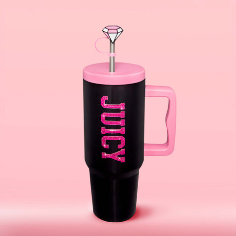 Show off your style with the GoGlam Hydration Bling Stainless Steel Tumbler with Handle and Straw with Topper (40 oz)—a tall, black, insulated cup featuring a pink handle and lid. “JUICY” is displayed in sparkly pink letters across the front. This cup-holder-friendly tumbler comes with a reusable straw topped by a gem-shaped decoration, set against a solid light pink background.