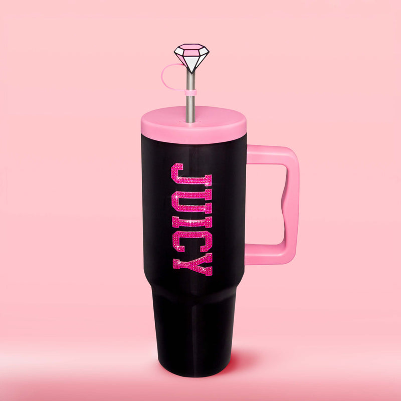 Show off your style with the GoGlam Hydration Bling Stainless Steel Tumbler with Handle and Straw with Topper (40 oz)—a tall, black, insulated cup featuring a pink handle and lid. “JUICY” is displayed in sparkly pink letters across the front. This cup-holder-friendly tumbler comes with a reusable straw topped by a gem-shaped decoration, set against a solid light pink background.