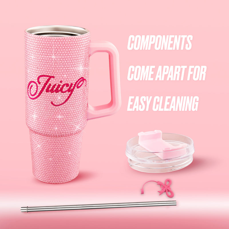 The BlingSip Rhinestone Tumbler with Handle, Straw, and Topper is a pink, rhinestone-covered insulated stainless steel tumbler featuring “Juicy” written on the side. It includes a handle, lid, metal straw, and cleaning tool, with components that come apart for easy cleaning. Shown against a pink background.