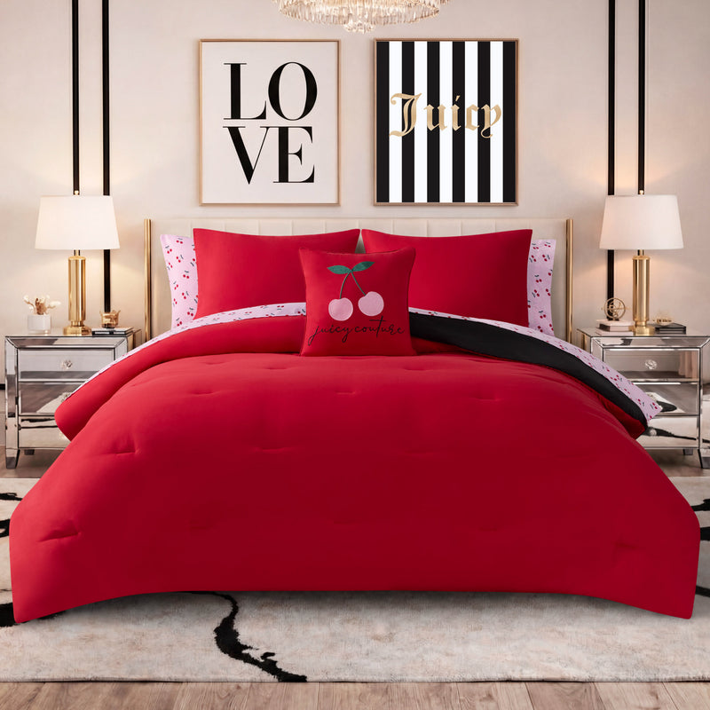 A modern bedroom featuring the Cherry Toss Cheetah Solid Reversible Comforter Bed in a Bag Bedding Set, paired with matching pillows, silver nightstands, two lamps, and wall art displaying the words LOVE and Juicy. The stylish decor is highlighted by a cherry-themed accent pillow and chic Juicy Couture bedding, with the reversible comforter set adding versatile flair to the space.