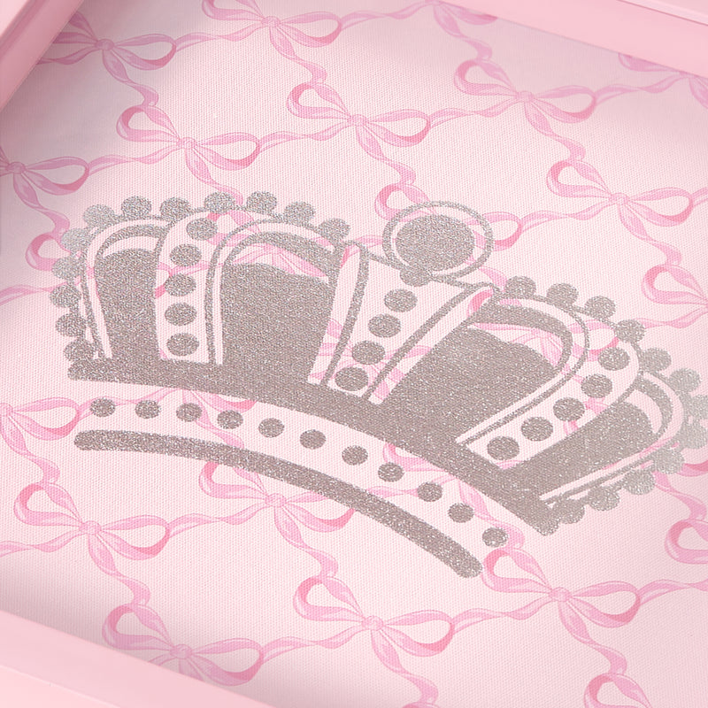 A glittery silver crown is centered on a pink background adorned with a pattern of light pink bows in this 14″ x 14″ Shadow Box Wall Art. Reminiscent of Juicy Couture decor, the design features decorative dots and arches for a soft, feminine touch.