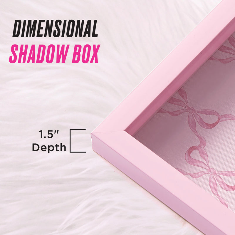 Shadow Box Wall Art, 14″ x 14″, displayed on white fur and labeled DIMENSIONAL SHADOW BOX with a 1.5-inch depth. This fashion-inspired piece features a pink bow pattern in the background, making it a chic choice for anyone who loves Juicy Couture wall art.