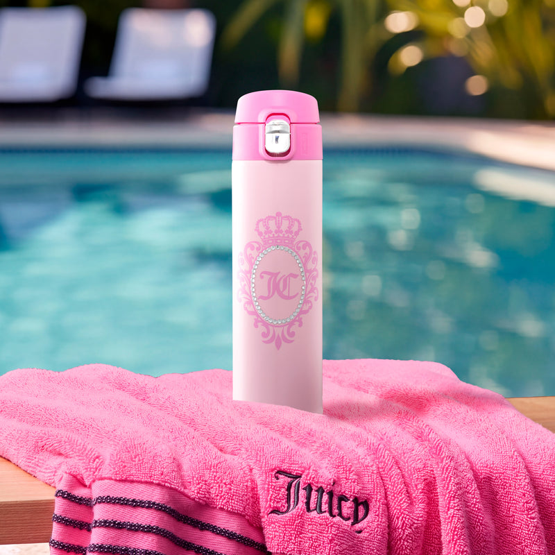 A pink Pop Top Lid Stainless Steel Tumbler, 15 oz, sits on a pink towel by a swimming pool.