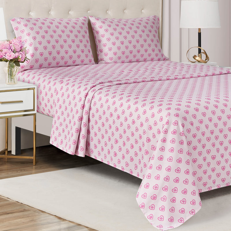 Bed made with a Printed Microfiber Sheet Set featuring white linens with a repeating pattern of small pink hearts.