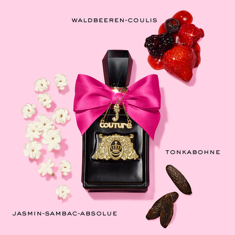 A black perfume bottle with a pink bow and gold charm from the Viva La Juicy 3 Piece Fragrance Gift Set is surrounded by white flowers, dark beans, and mixed berries on a pink background. Playful elegance comes to life as vibrant aromas of berries, jasmine, and tonka bean evoke the signature scent of this Juicy Couture collection.