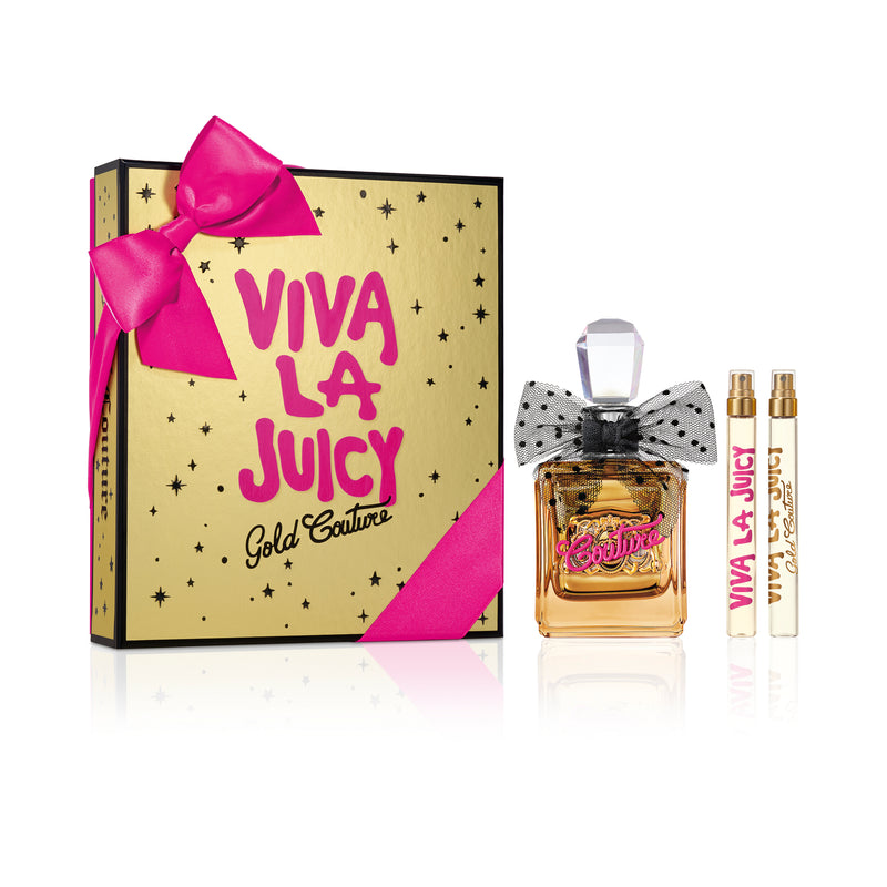 The Viva La Juicy Gold Couture 3 Piece Fragrance Gift Set features a bow-topped bottle of Juicy Couture perfume and two mini sprays, all presented beside a gold box with pink lettering and black dots, finished with a pink ribbon.