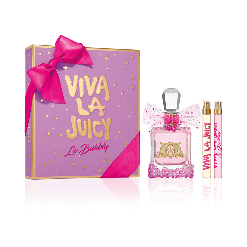The Viva La Juicy Le Bubbly 3 Piece Fragrance Gift Set is displayed against a white background, featuring a pink and gold box with a ribbon, a decorated Juicy Couture perfume bottle, and two slim spray tubes.