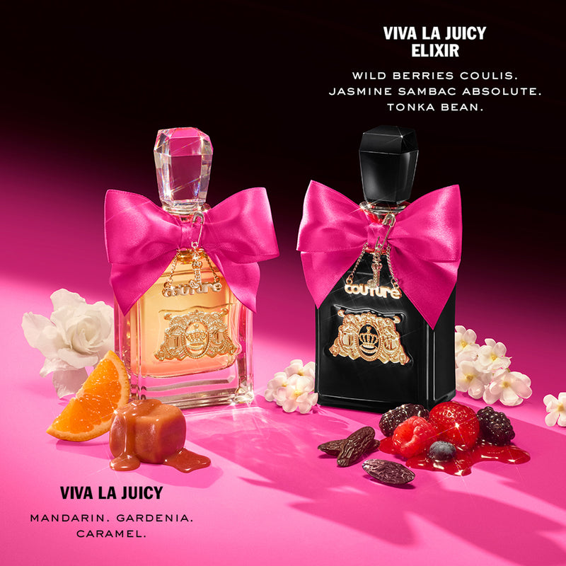 Two perfume bottles—one clear and one black—each adorned with a pink bow and gold label, are artfully arranged among mandarin slices, caramel, berries, and flowers atop a pink surface. Text details the fragrance notes of each eau de parfum included in the Viva La Juicy Elixir 3 Piece Fragrance Gift Set from the iconic Juicy Couture collection, highlighting vibrant scents like Viva La Juicy Elixir.