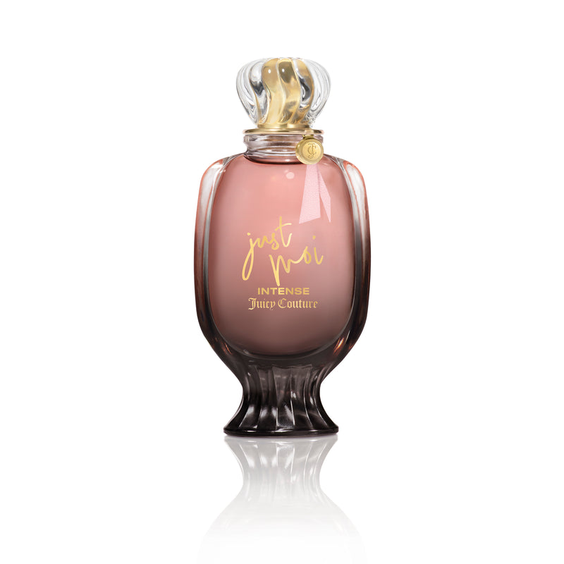 A pink and gold Just Moi Intense Eau de Parfum Spray, 3.4 oz by Juicy Couture stands upright on a white background, featuring a decorative cap and curved glass—an Amber Vanilla scent designed for women.