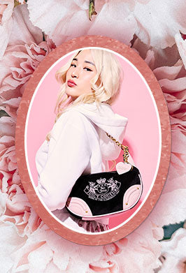 Person holding a black and pink handbag with floral background