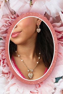 Woman wearing a necklace and earrings with a pink floral background