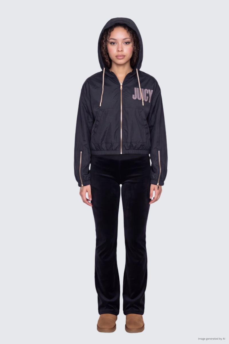 A person wears a black faux fur Statement Jacket with a front zipper and crystal Juicy logo on the chest, paired with black flared pants and tan slippers.