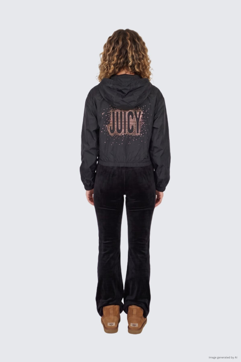 View from behind of a person wearing a black velour Statement Jacket featuring a rose gold glitter crystal Juicy logo on the back, with matching black velour pants and tan ankle boots.