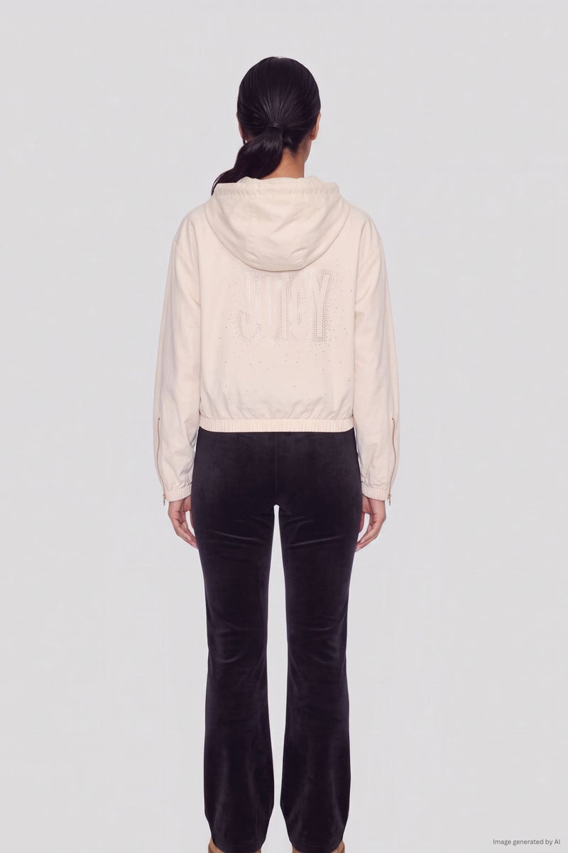 A person seen from behind wears a Statement Jacket, featuring a light-colored, faux fur hood with the word JUICY in rhinestones on the back, paired with dark pants.