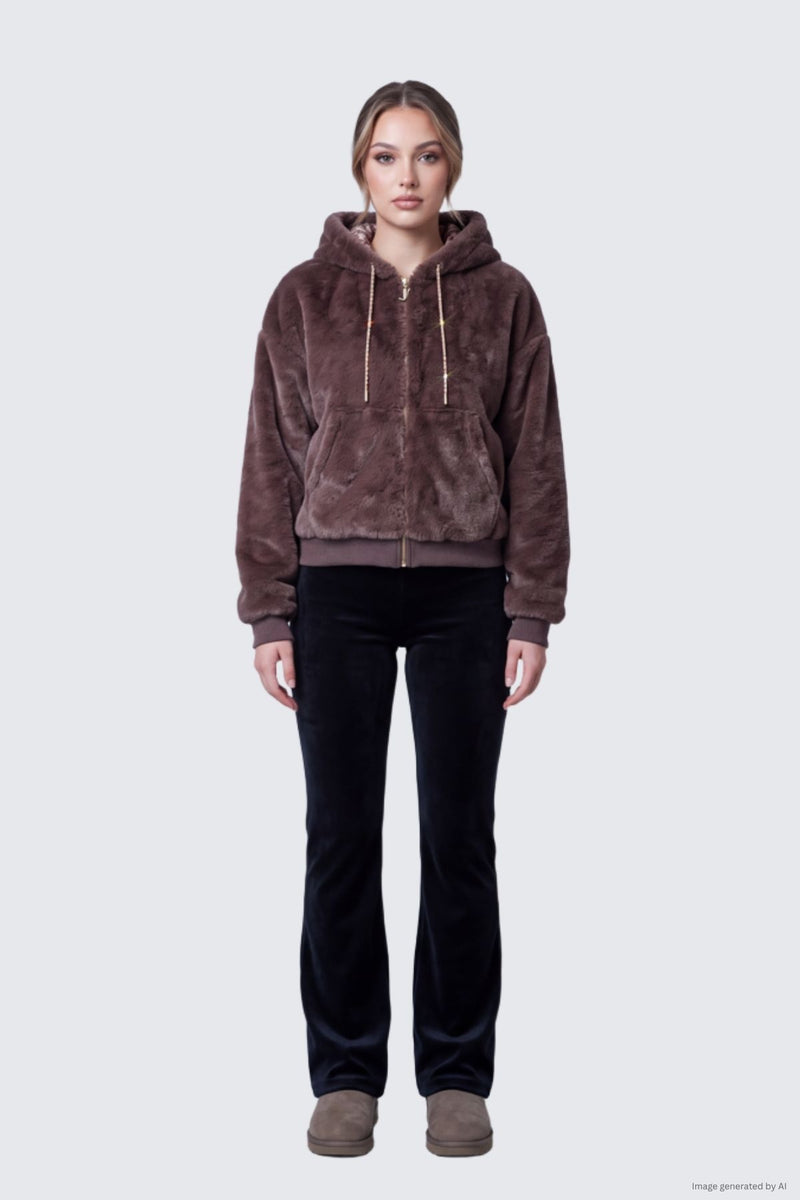 A woman wears a brown Juicy Fur Jacket with a hood and zip-up front, styled with black trousers and brown boots.