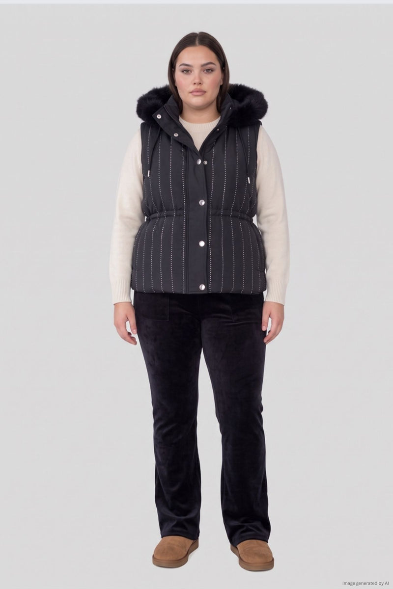 A person wearing a Plus-Size Bling Puffer Vest with white dotted vertical stripes and a faux-fur trimmed hood over a cream sweater and black pants.