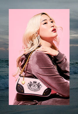 Woman holding a black and white handbag with a pink background, framed in an image of a dark beach