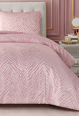 Pink zebra print bedding set on a bed with a matching headboard.