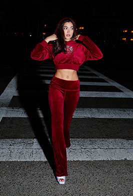 Woman in a red Juicy Couture tracksuit standing on a crosswalk