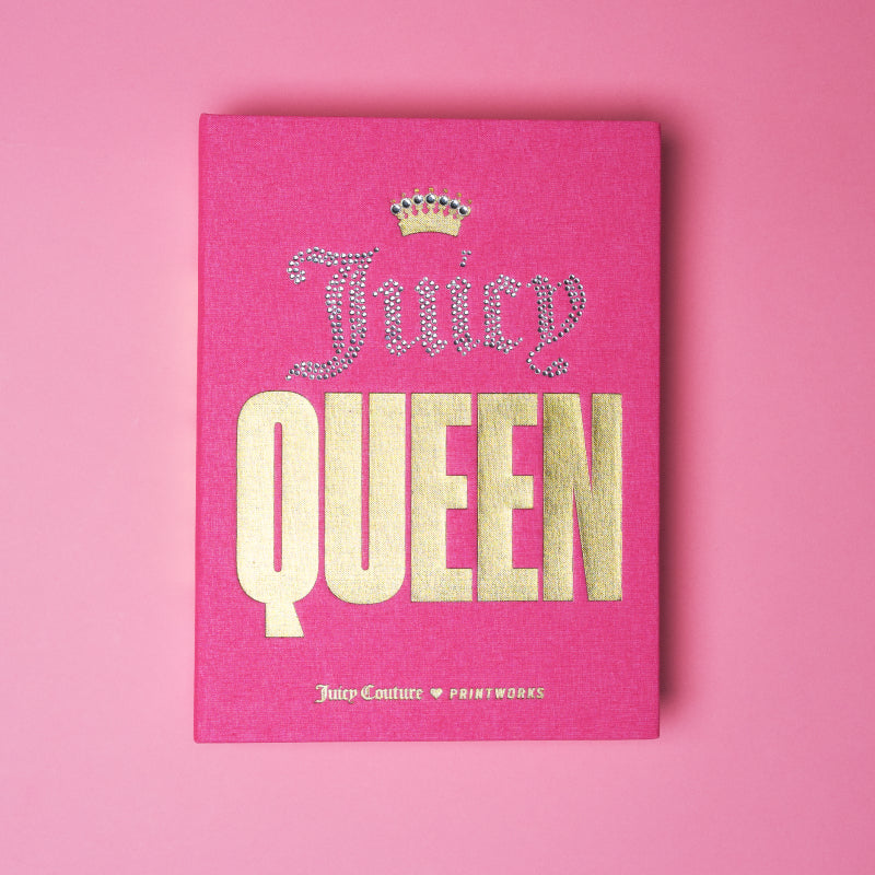 Introducing the Juicy Couture x Printworks Jewelry Box: a stylish pink piece inspired by book-themed designs, featuring “Juicy QUEEN” in jeweled and gold lettering on the cover and topped with a sparkling crowned accent. With both the Juicy Couture and Printworks logos elegantly placed at the bottom, this jewelry box is perfect for anyone who loves chic pink storage imbued with regal charm.