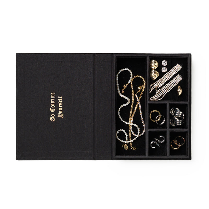 Juicy Couture x Printworks Jewelry Box: A black jewelry box featuring gold “Go Couture Yourself” text on the lid, inspired by Juicy Couture’s iconic style, with separate compartments to elegantly organize necklaces, rings, earrings, and bracelets.