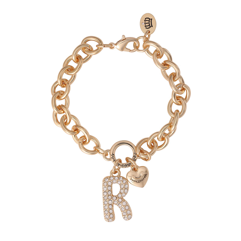 The Pavé Initial Charm Bracelet, Letter R features a gold chunky design adorned with a large, rhinestone-encrusted “R” initial charm and a petite heart charm. This Juicy Couture piece also showcases a circular tag with the iconic logo near the clasp, blending elegance and playfulness for a standout charm bracelet.